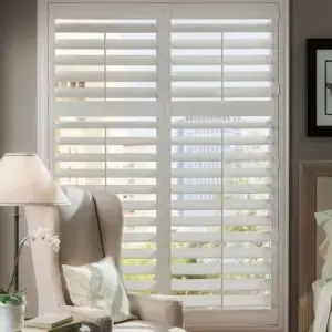 Beautiful white wood plantation style interior window shutters installed on living room windows.